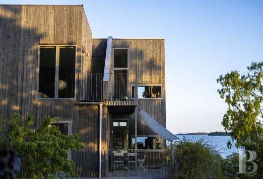 Sur l'île d'Oaxen, dans l'archipel sud de Stockholm, une villa d'architecte avec maison d'hôtes et emplacement ...